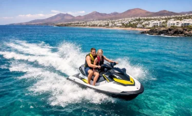 Jet ski Lanzarote aerial view tourists riding jet ski in the Atlantic Ocean near Puerto del Carmen volcanic coastline