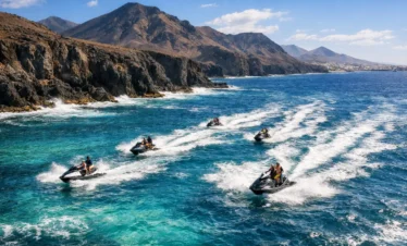 Jet ski tour Lanzarote aerial drone view of jet skis riding across the Atlantic Ocean with volcanic landscape