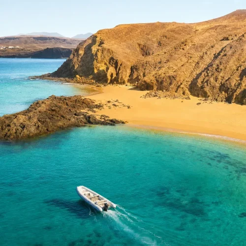 Private boat anchored in turquoise water at Papagayo Beaches Lanzarote